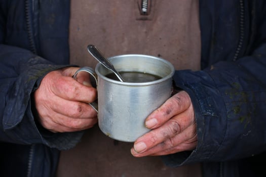 Poor man holding tea to keep warm in winter. photo