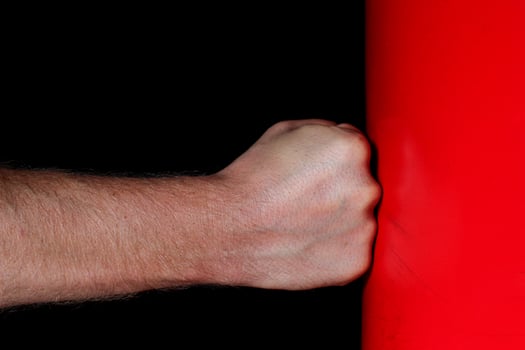 Fist punching a punching bag. Symbol of aggression and strength. photo