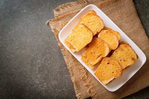Baked crispy bread with butter and sugar on plate photo