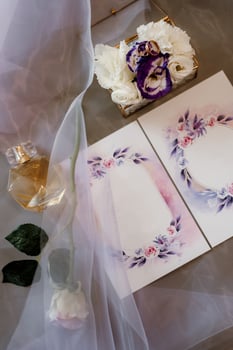 wedding invitation in a gray envelope on a table with green sprigs photo