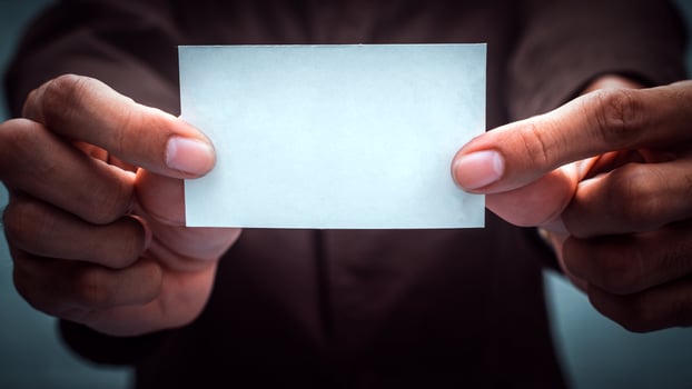 Businessman holding white business card. Mockup bank paper for ads and text. photo