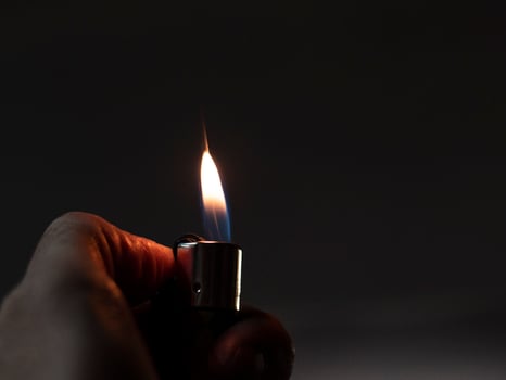 Mens hands hold lighters, fire from cigarette photo