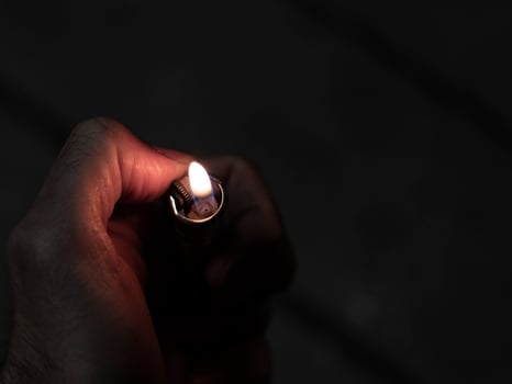 Men's hands hold lighters, fire from cigarette photo