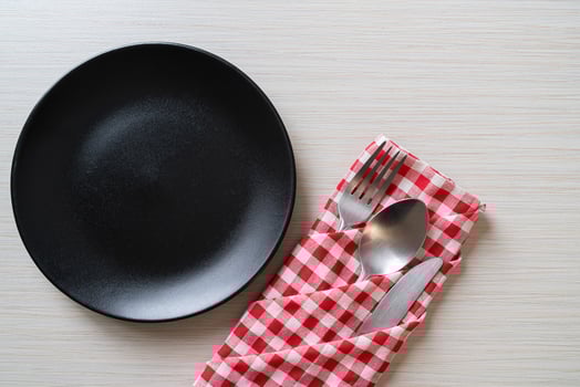 Empty plate or dish with knife, fork, and spoon on wood tile background photo