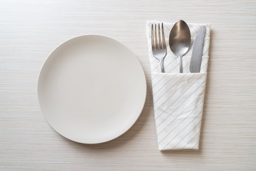 Empty plate or dish with knife, fork, and spoon on wood tile background photo