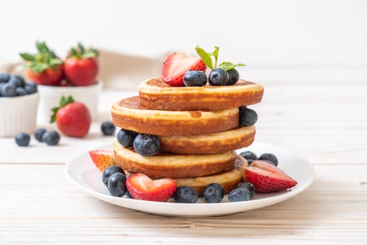 Souffle pancake with fresh blueberries, fresh strawberries and honey photo