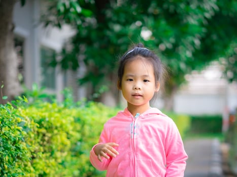 Little Asian girl wear jacket in the park photo