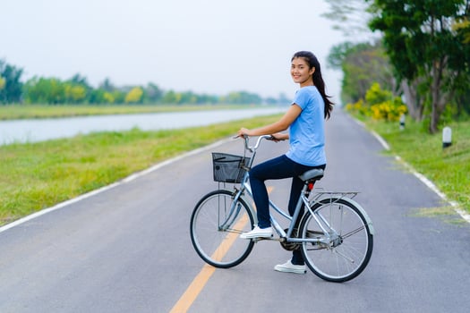 Girl with bike, Woman riding a bicycle on road in a park photo