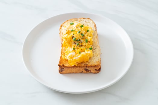 Bread toast with scramble egg on white plate photo