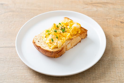 Bread toast with scramble egg on white plate photo