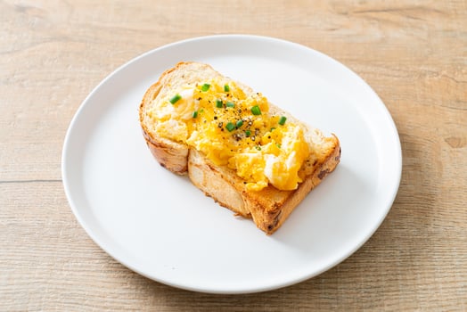 Bread toast with scramble egg on white plate photo