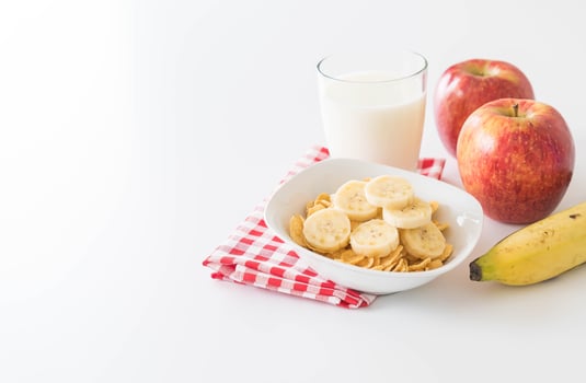 Milk, apple, banana, and cornflakes for breakfast photo