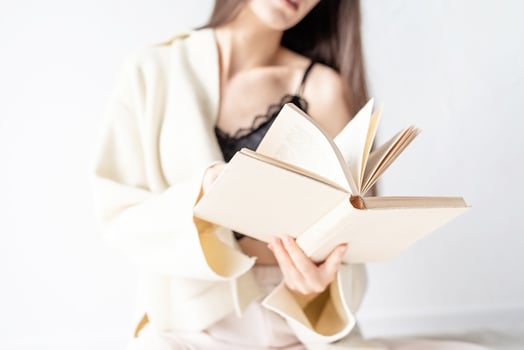 woman in comfortable home clothes reading a book sitting on the floor photo