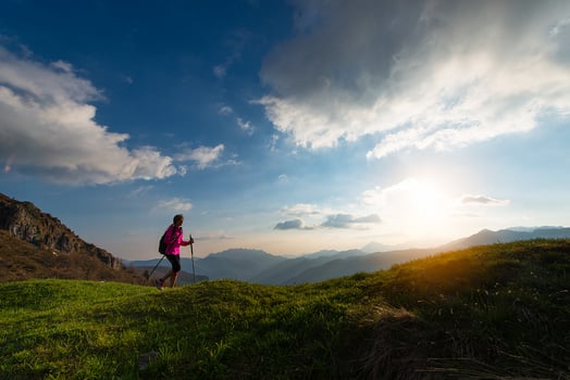 Slender woman practicing nordic walking in the mountains photo