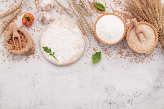 The ingredients for pizza dough set up on white concrete background photo