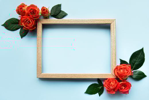 Flowers composition. Wooden frame and red  roses and leaves photo
