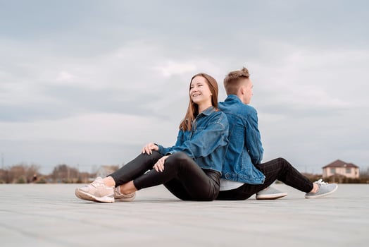 couple sitting back to back in the street spending time together photo