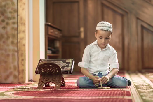 Ramadan Kareem,beautiful boy Muslim is praying in mosque photo