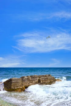Seascape with a rock in the waves. photo