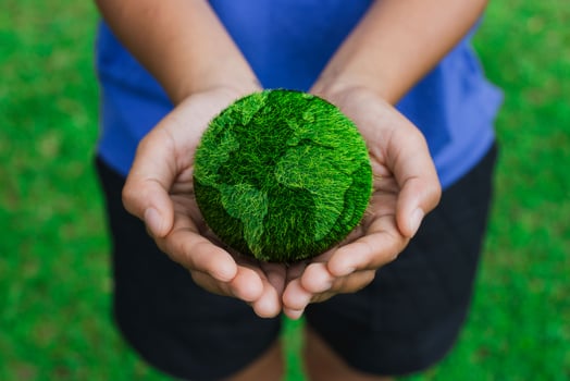 Women hands holding earth on green background photo