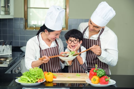 Asian woman young mother with son boy cooking salad photo