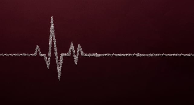 Heart rate graph using white sugar on red background photo