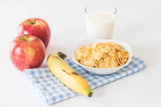 Milk, apple, banana and cornflakes for breakfast photo