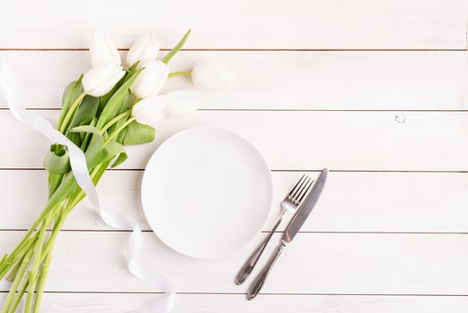 Festive table setting in white, white plate and tulips photo