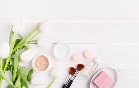 cosmetic creams and soap with white tulips top view flat lay photo