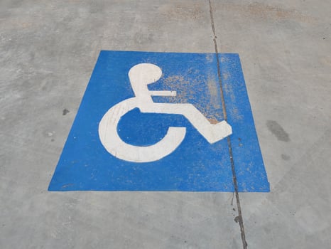 Blue sign on the asphalt about disabled parking photo