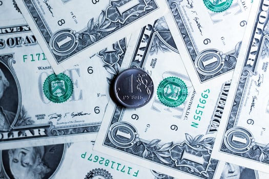 One ruble coin against the background of notes of american dollars. photo
