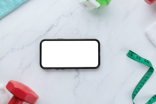 Smartphone with blank screen and fitness equipment photo