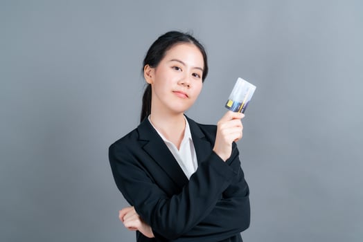 Portrait of a lovely young Asian woman showing credit card photo