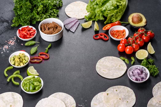 Mexican tacos with beef, tomatoes, avocado, onion and salsa sauce photo
