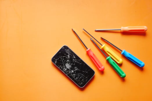 Top view of broken smart phone on color background photo