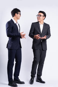 Two Asian businessmen walking on white background photo