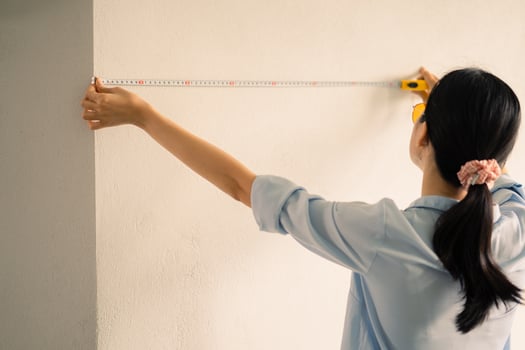 Asian woman measuring the size of the wall photo