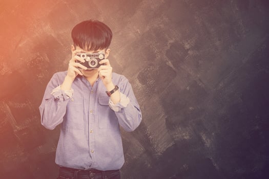 Portrait of a young man wearing jeans and  shirt hipster style  doing photo