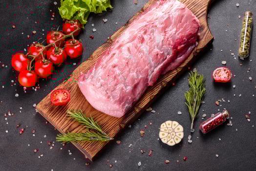 Fresh pieces pork ready to cook on a dark background in the kitchen photo