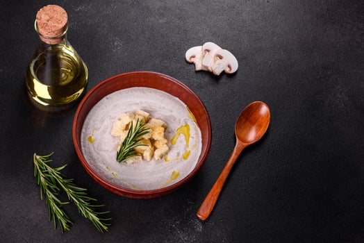 Delicious beautiful mushroom soup in a brown plate with a wooden spoon photo