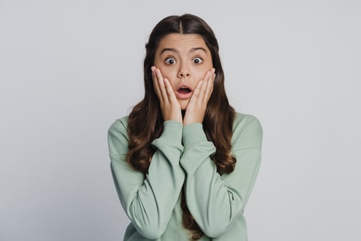 Beautiful teenage girl touches her face with her hands photo