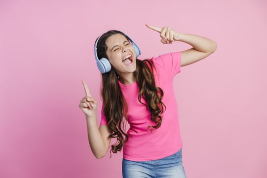 Teenage girl in headphones listens to music, enjoys music, dances photo