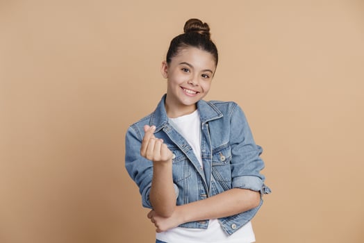Cunning, smiling girl shows a sign of money photo