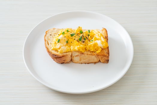Bread toast with scramble egg on white plate photo