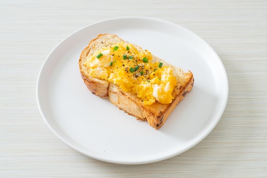 Bread toast with scramble egg on white plate photo