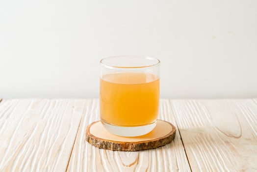 Fresh and hot ginger juice glass with ginger roots - Healthy drink style photo