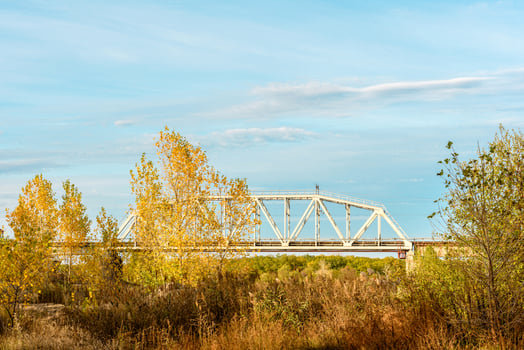 A metal railway bridge connecting two river banks photo