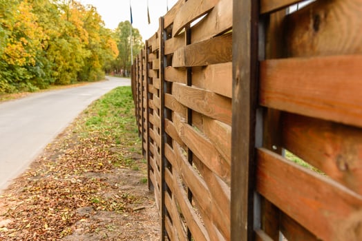 An old fence of wooden planks around a plot of land photo