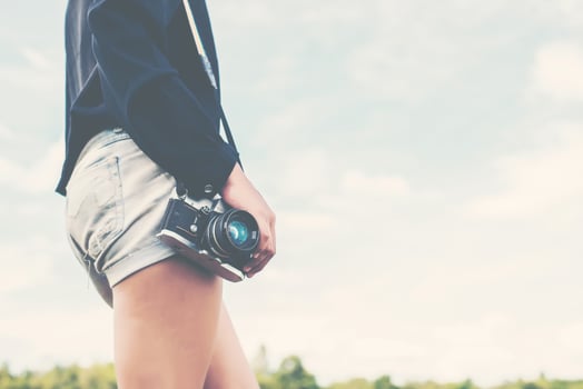 Beautiful women photographer standing hand holding retro camera photo