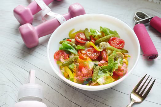 Fitness concept with dumbbell, fresh vegetable and measurement tape photo